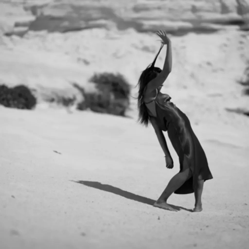 Femme dansant sur une dune de sable en robe