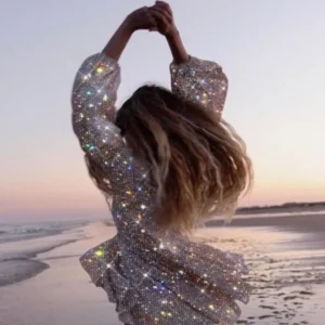 Femme qui danse sur la plage lors d'un voyage de danse avec une robe à paillettes