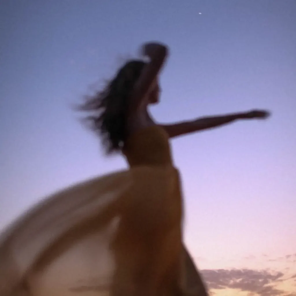 Femme habillée en robe longue entrain de danser quand la nuit tombe